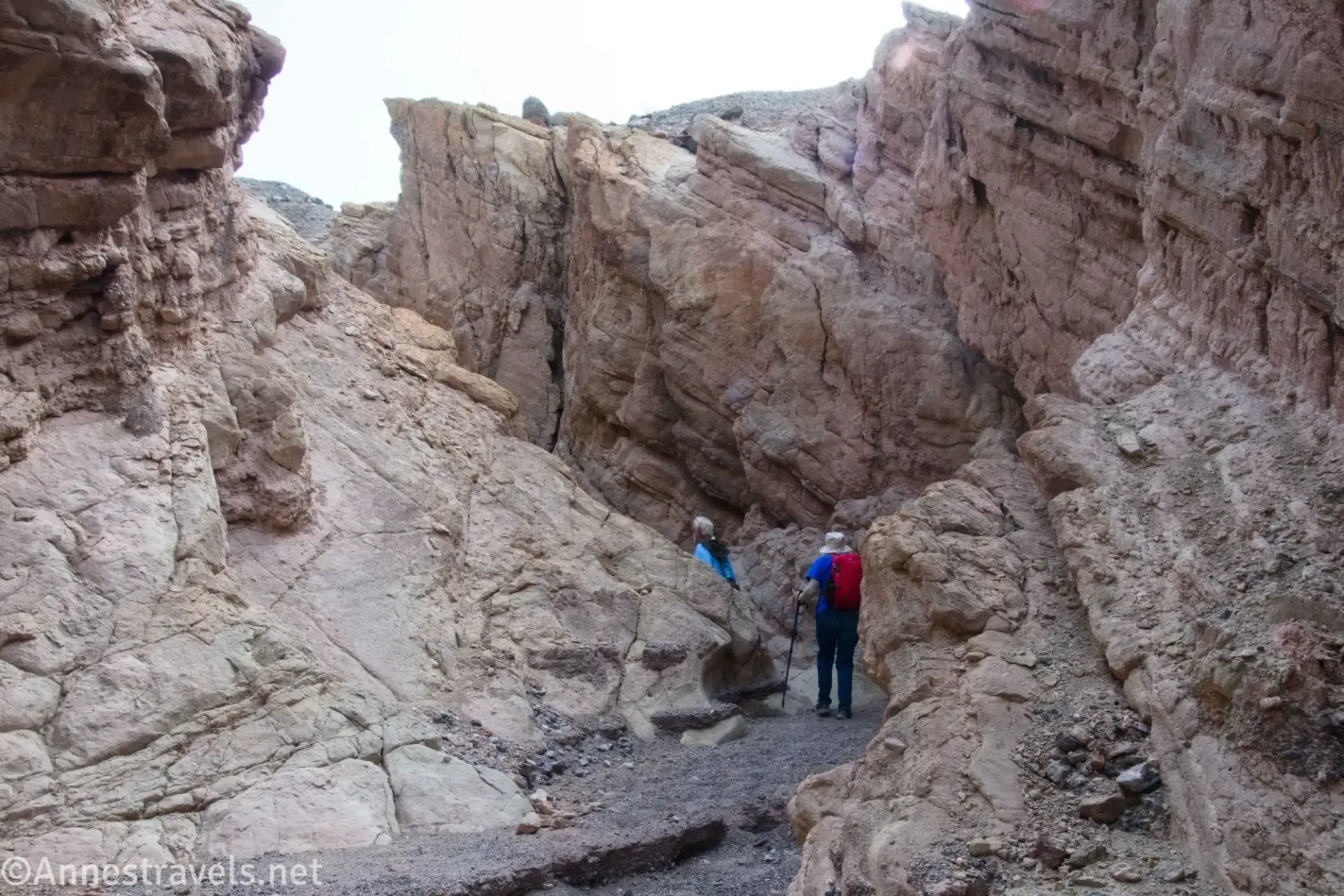 The Cauldron Slot Two hikers in a narrow desert canyon