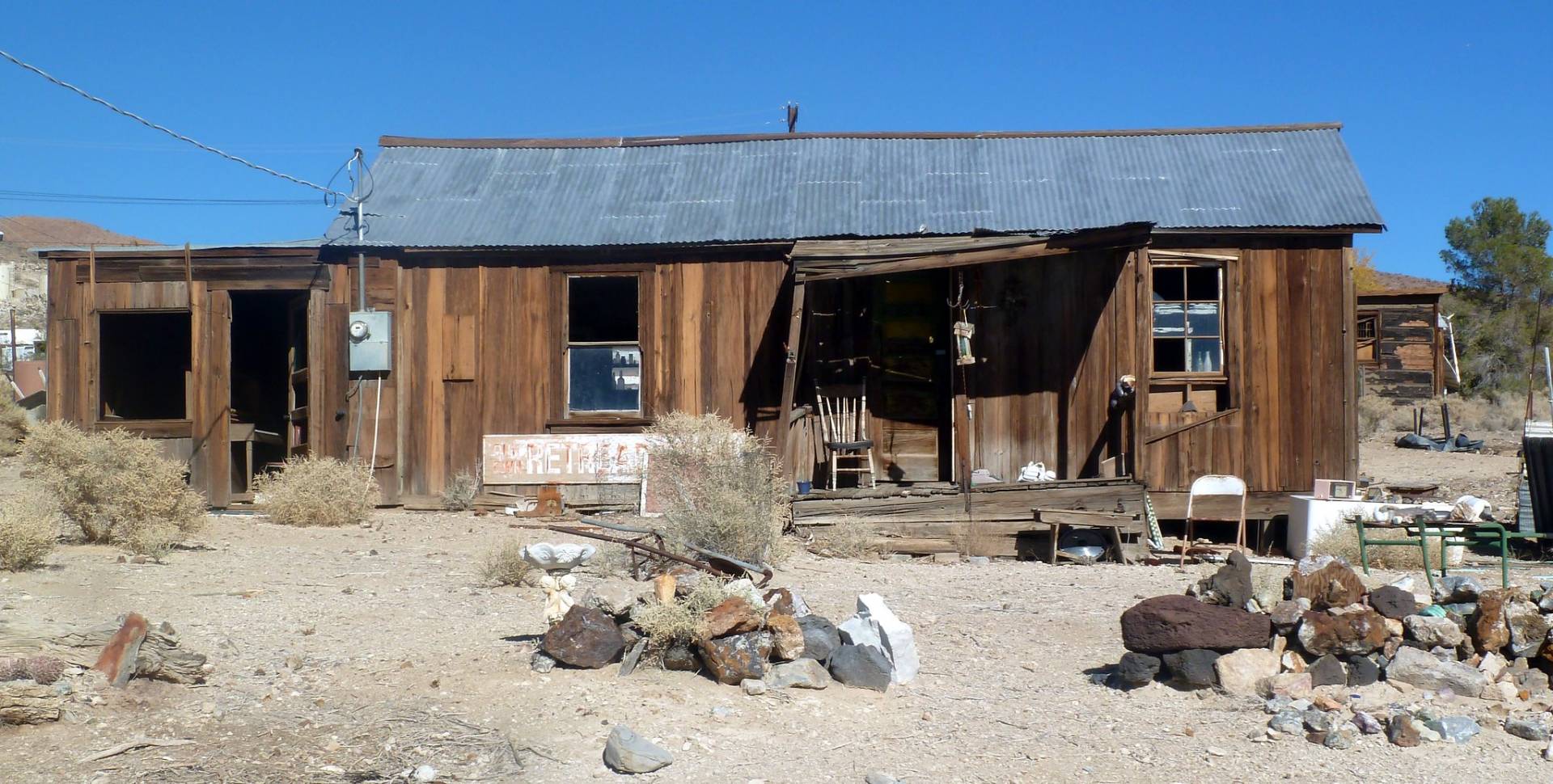 Old Cabin Slowly deteriorating wooden and tin roof building with rocks in front of it