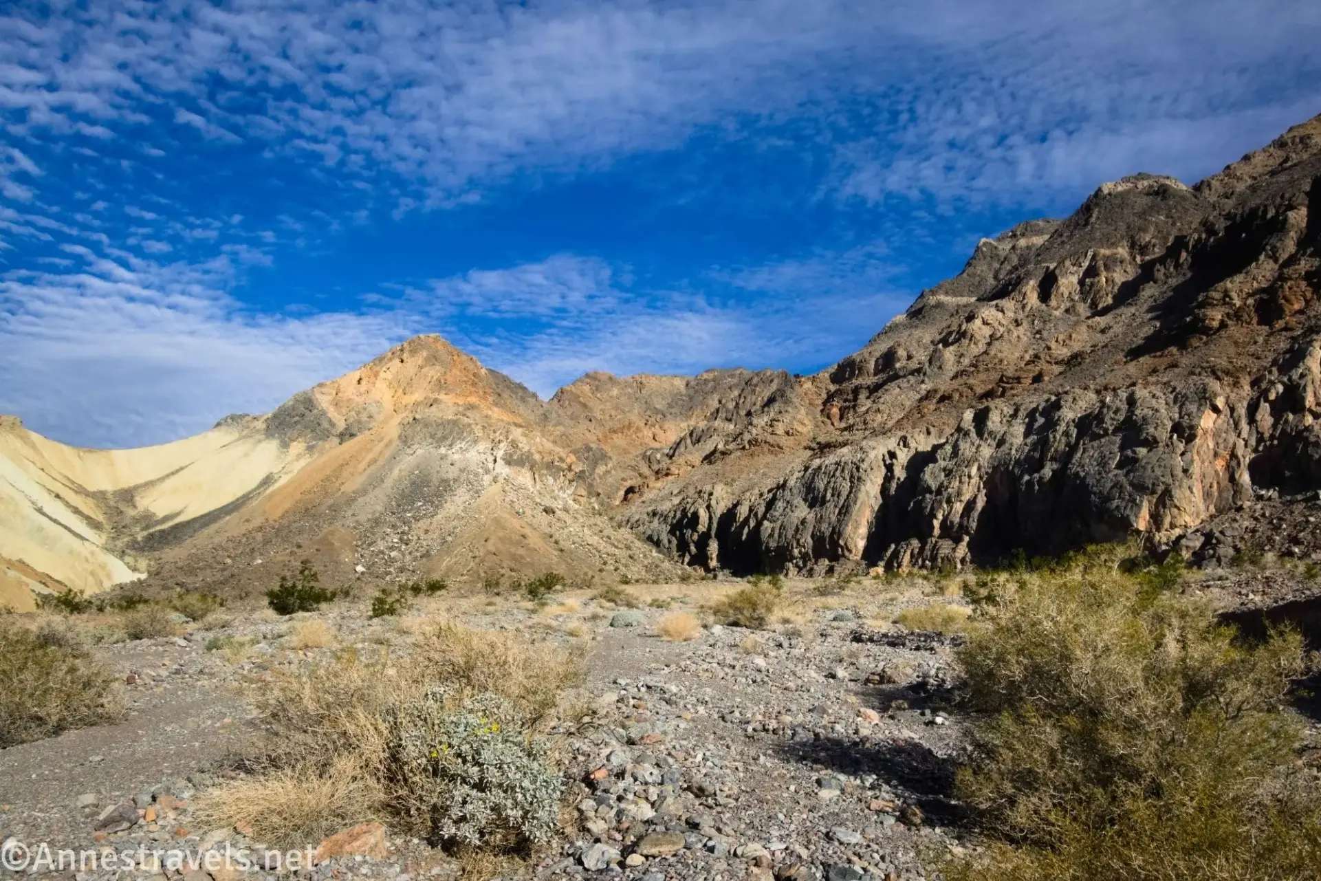 Heading for Slit Canyon Colorful badlands and cliffs beyond a gravel and brush wash