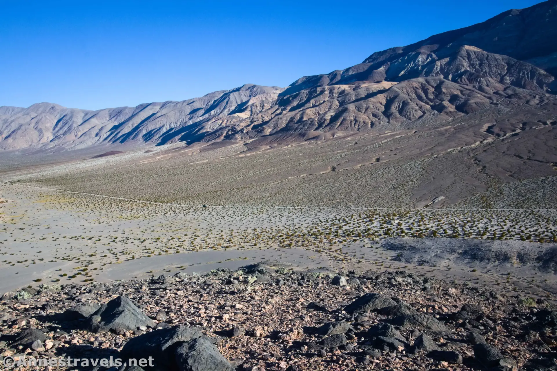 Lake Hill Road from Lake Hill A road across a desert plain between rocky ground an distant mountains