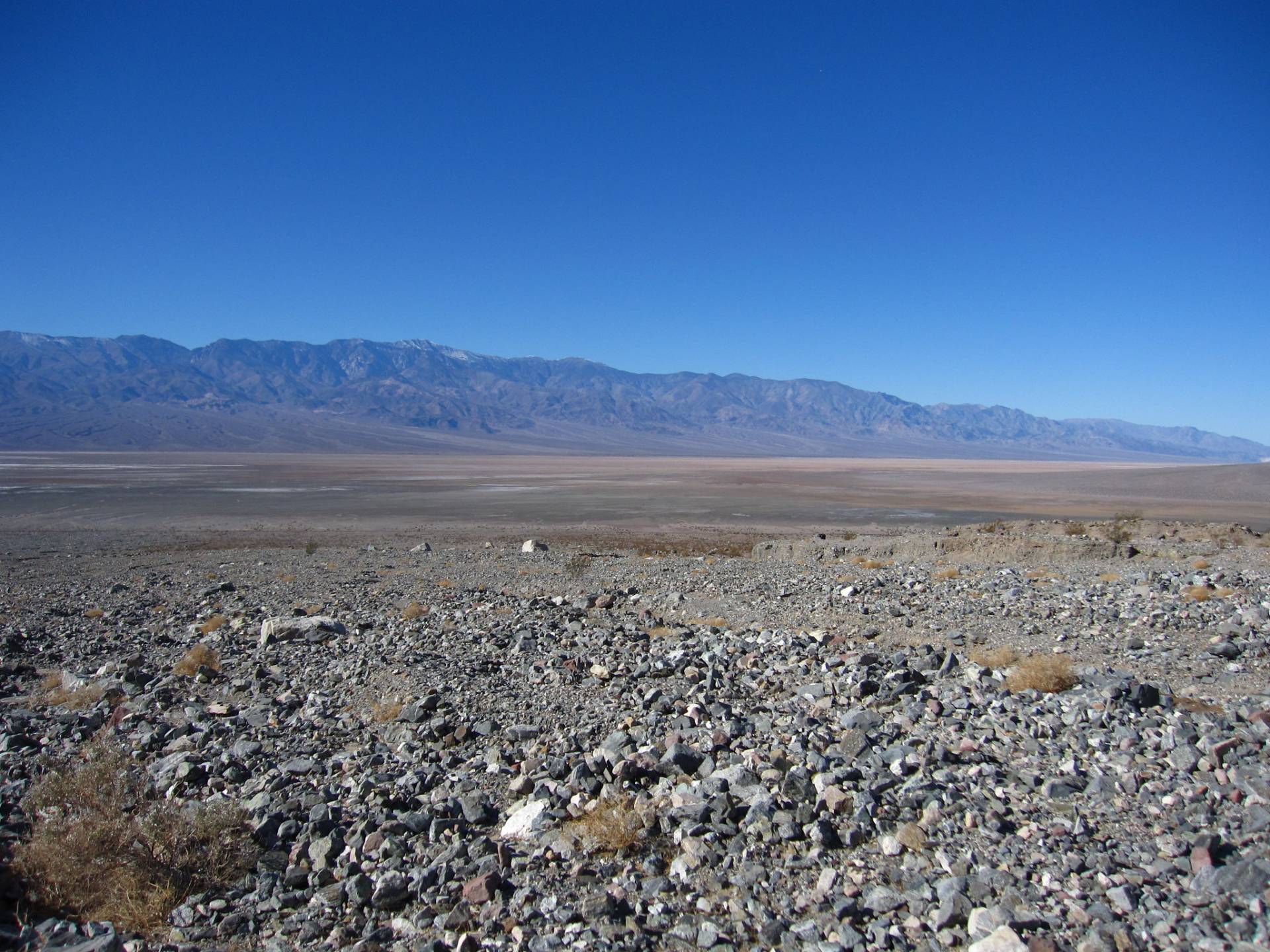 Sheep Canyon Alluvial Fan A rocky desert alluvial fan spreads down to a flat plain and mountains beyond