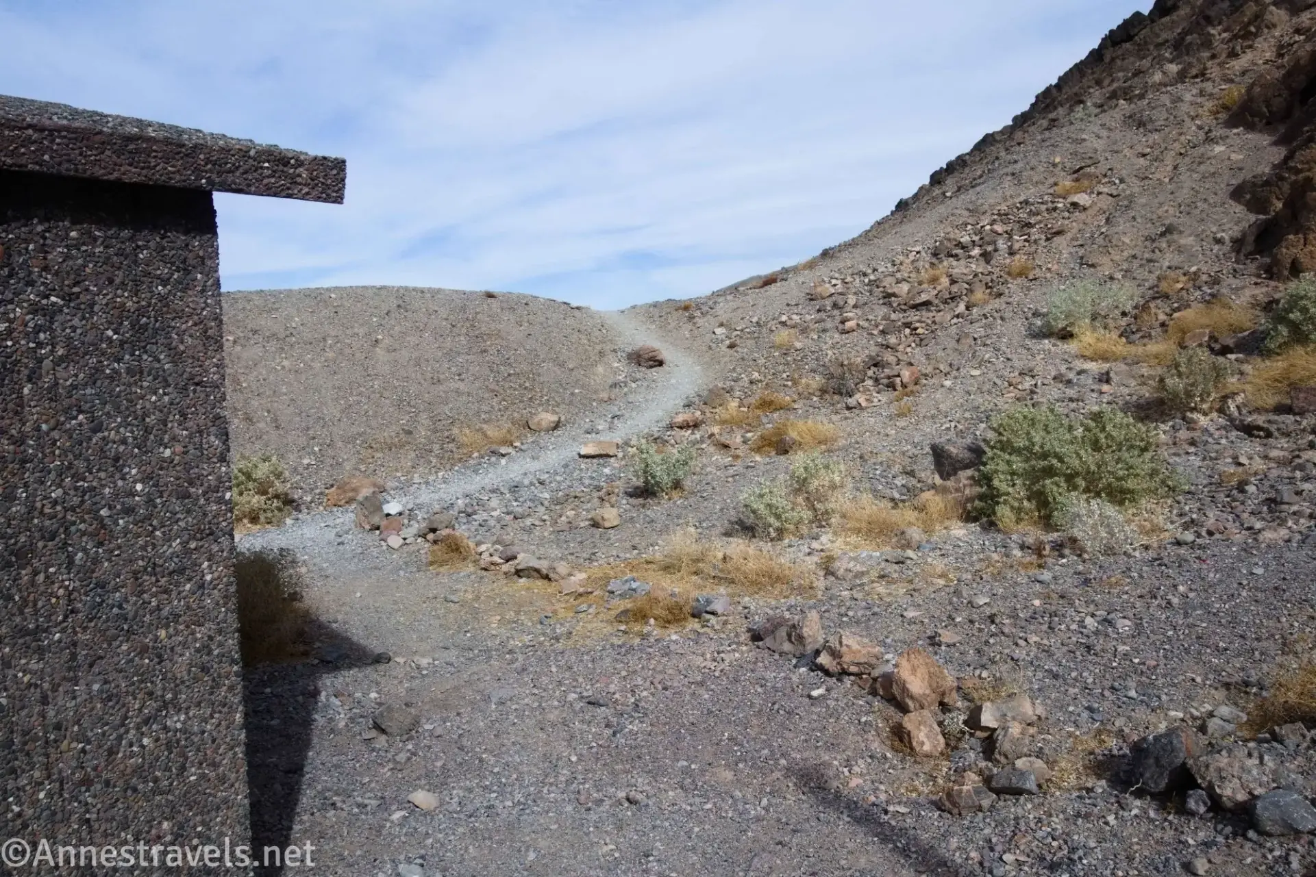 Fall Canyon Trailhead A trail on a gravel hill behind a gravel restroom