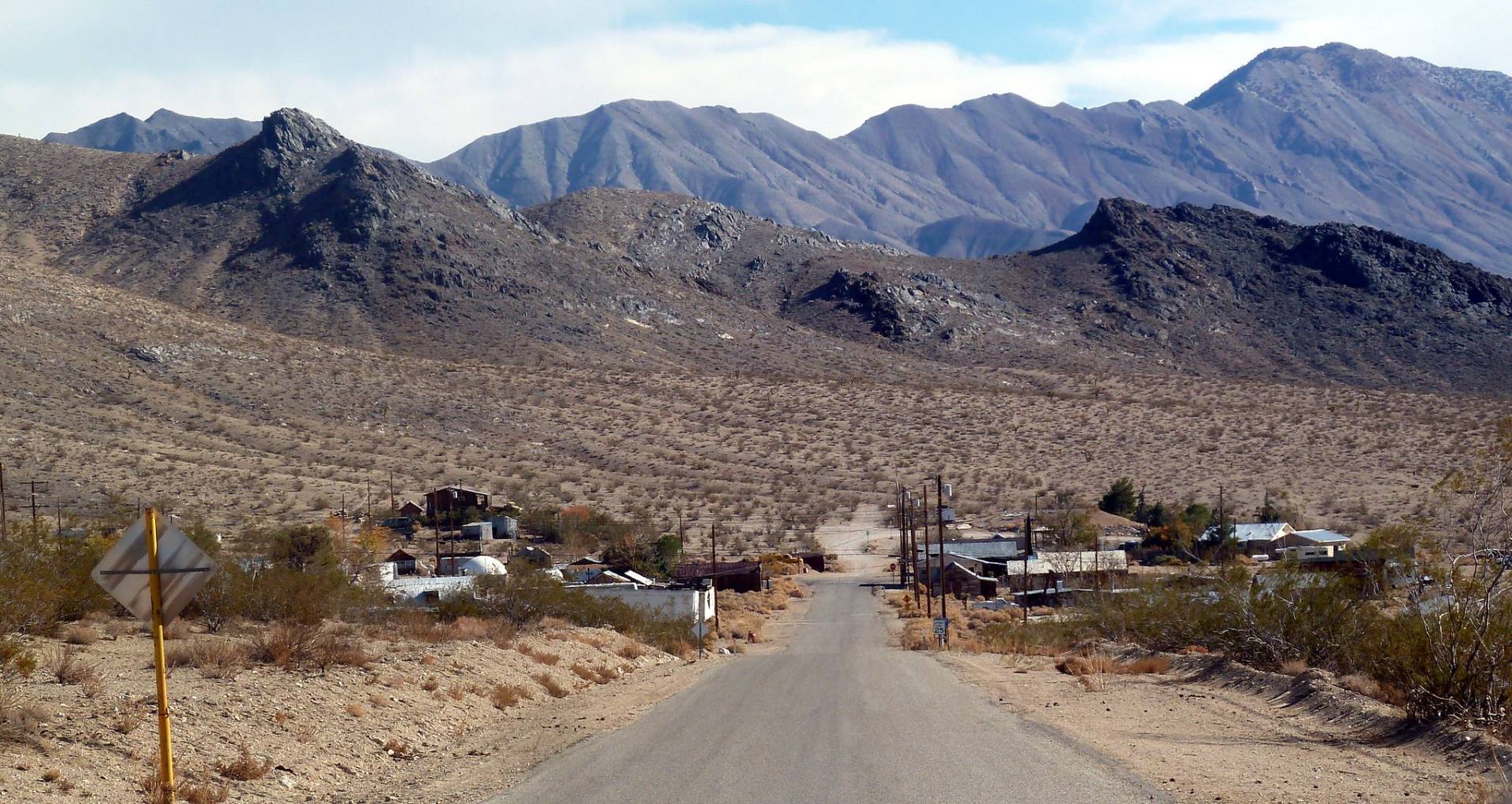 Darwin Ghost Town Road to a small ghost town on a desert plain below mountains