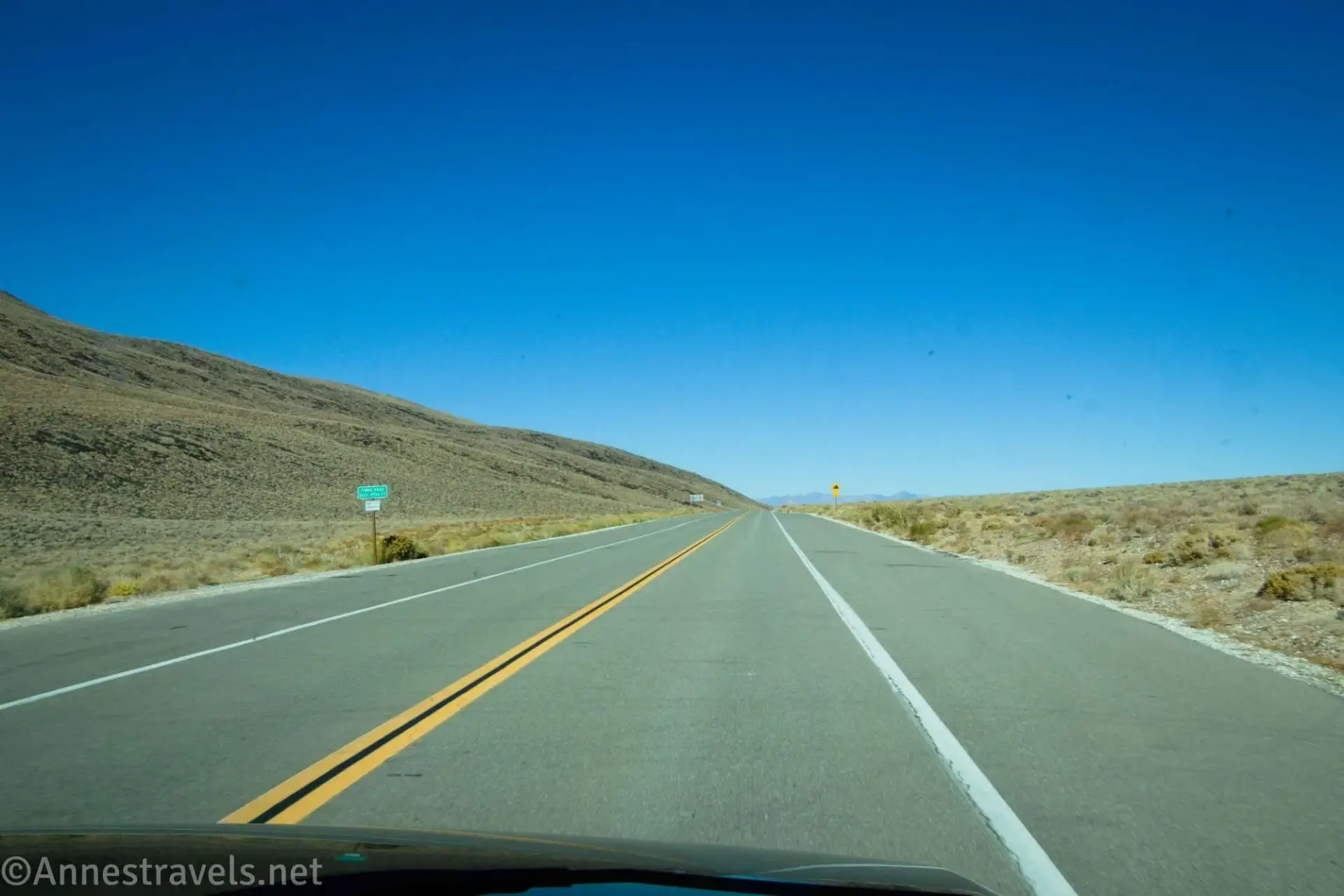 A blacktop road at a pass in the desert