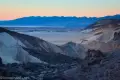 Sunset over Death Valley Sunset behind distant mountains across a valley and closer desert hills