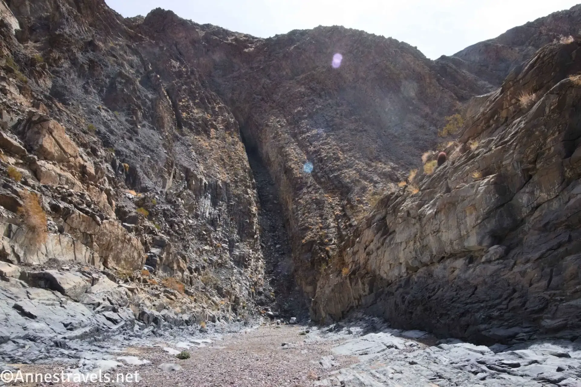 A straight canyon ends at a rocky wall