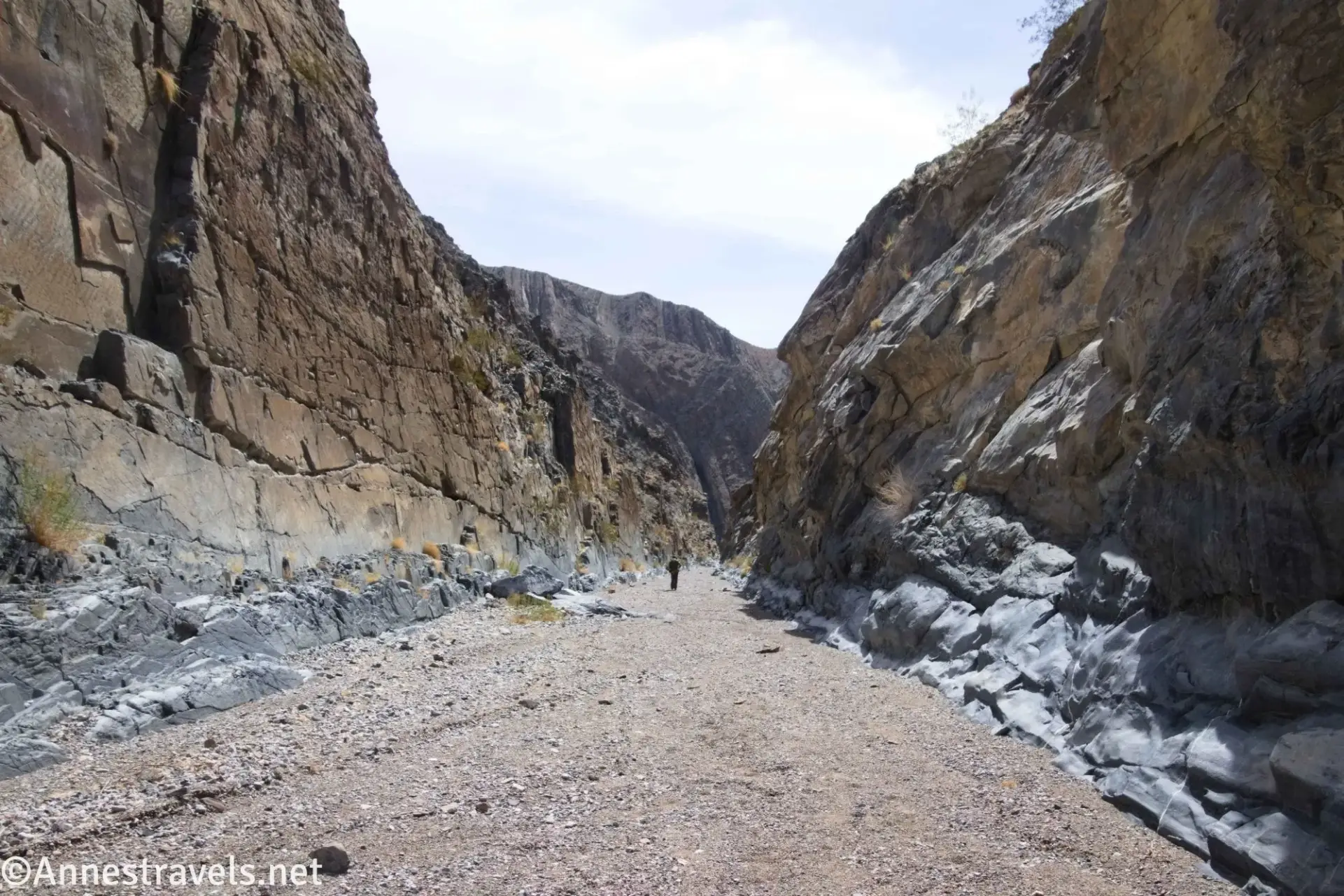 A very straight rock-bounded canyon with a gravel wash