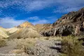 Heading for Slit Canyon Colorful badlands and cliffs beyond a gravel and brush wash