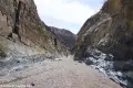 A very straight rock-bounded canyon with a gravel wash