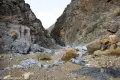 A gravelly wash leads to a narrow passage between rocky hills
