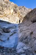 Another Dryall A hiker climbs a slick dryfall in a desert canyon