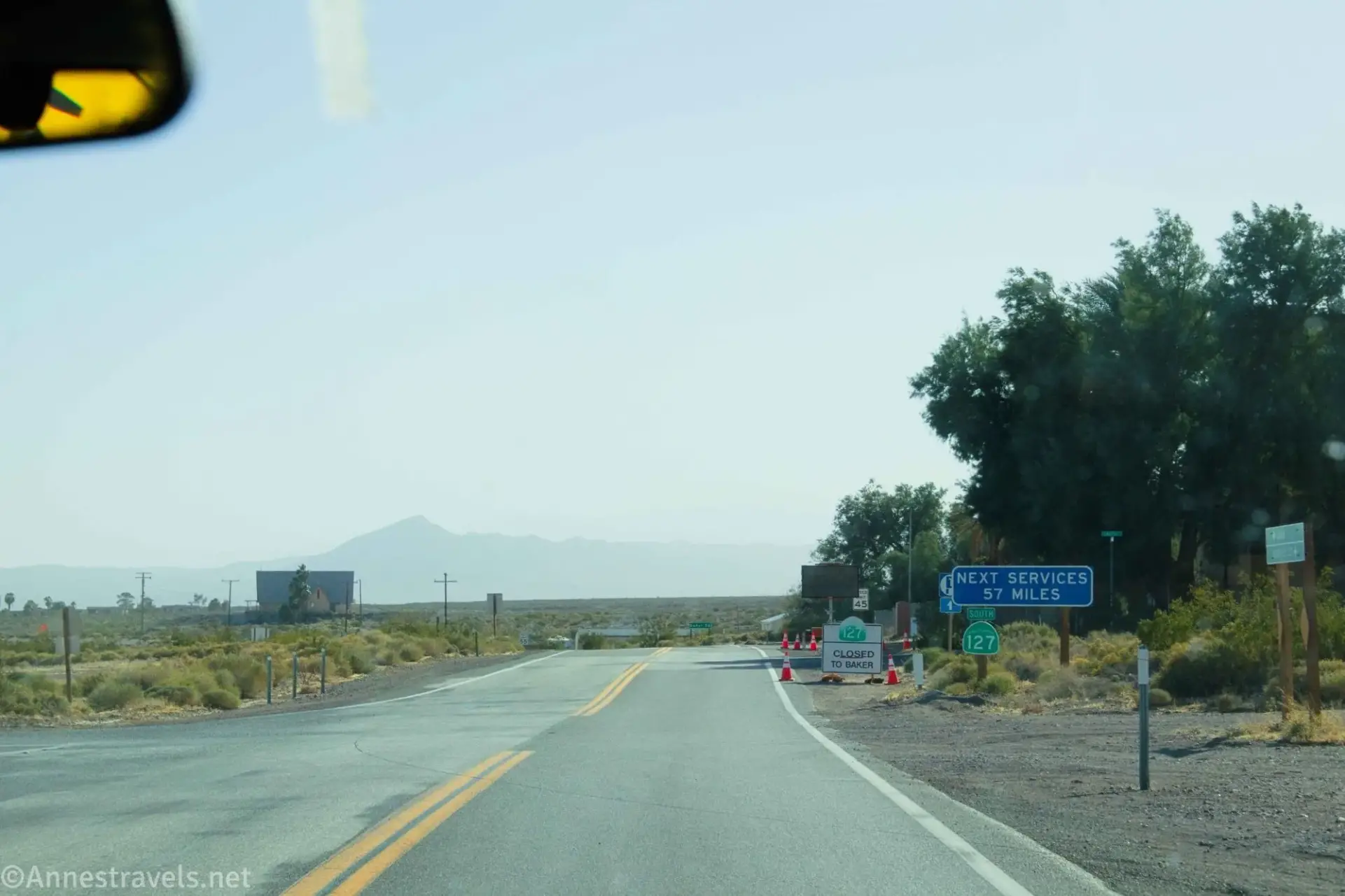Signs along a paved road through the desert