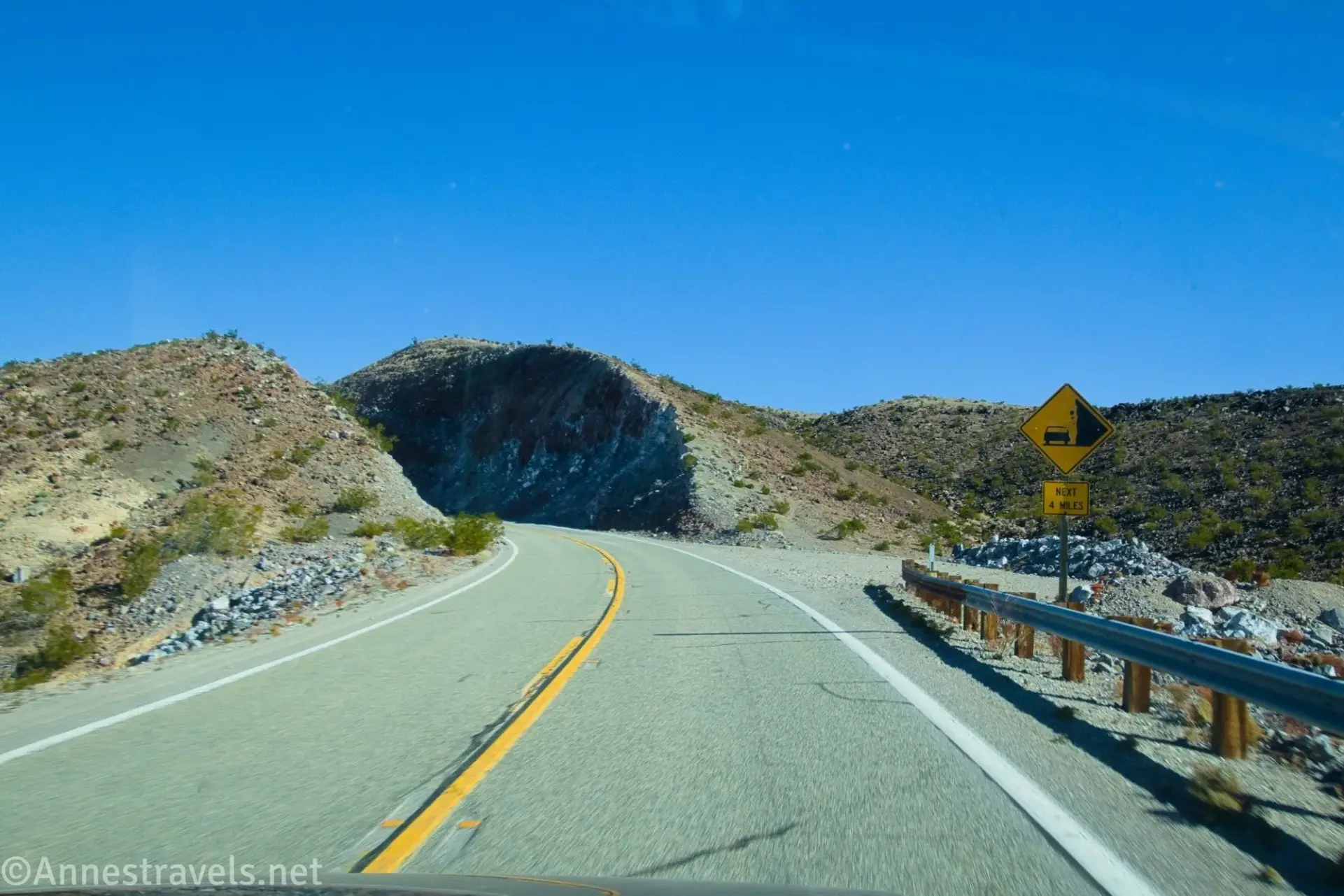 A falling rocks sign and cutting on a desert road