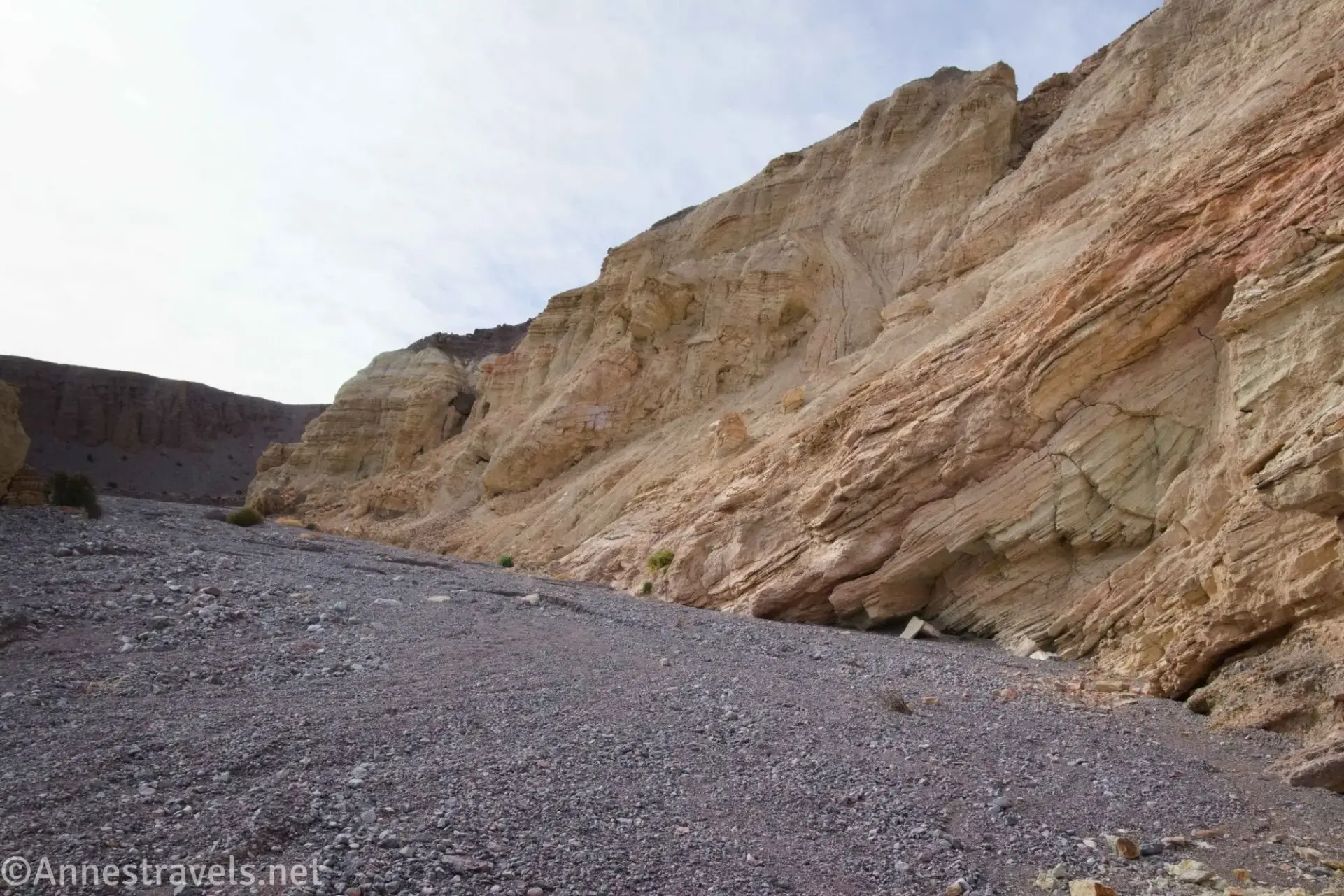 Yellow and red rock walls above gravel