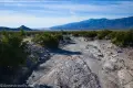 Wash in Panamint Valley A dry wash travels between green brush with distant desert mountains