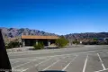 A stone building across the road with dry mountains beyond