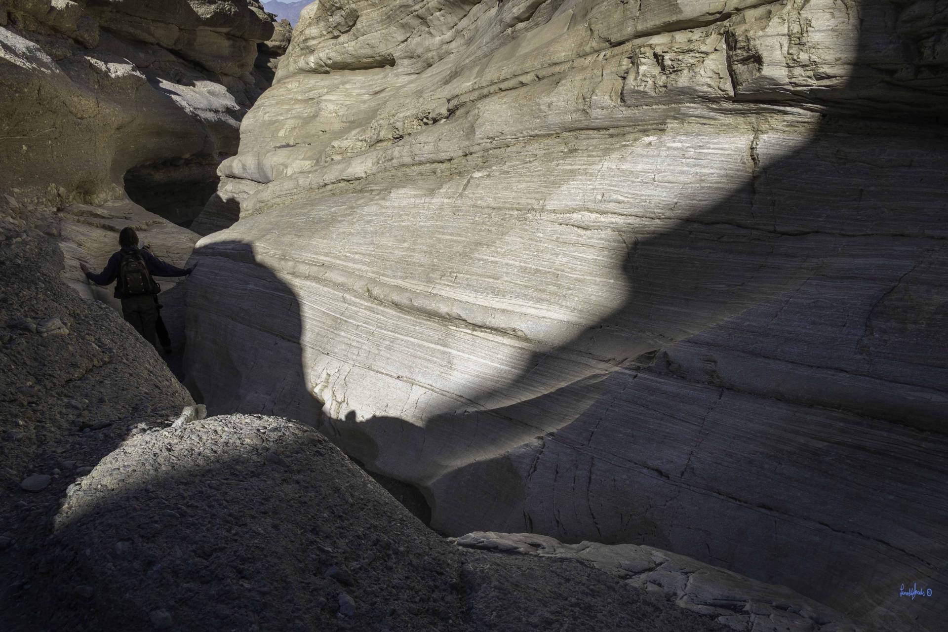 An extremely narrow section of canyon with a hiker at a small dryfall