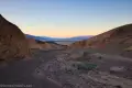 Colorful Side Fork of South Fork Desolation Canyon Sunset over distant mountains from a desert wash bordered by yellow hills