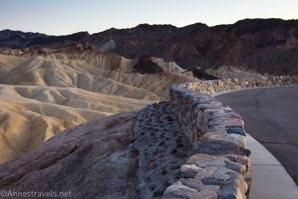 Yellow badlands beyond the stone wall of the Zabriskie Point Viewpoint in Death Valley National Park