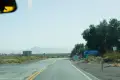 Signs along a paved road through the desert