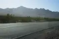 A paved road and hazy desert mountains