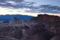 Darkness settles on Manly Beacon and badlands after sunset with clouds above at Zabriskie Point