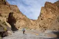 Palmer Canyon A hiker in a rugged desert canyon with multicolored walls