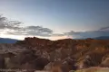 Muted red and striped badlands below sunset skies from Zabriskie Point in Death Valley National Park