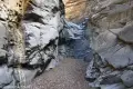 A canyon bounded by rock walls leads to a rock dryfall